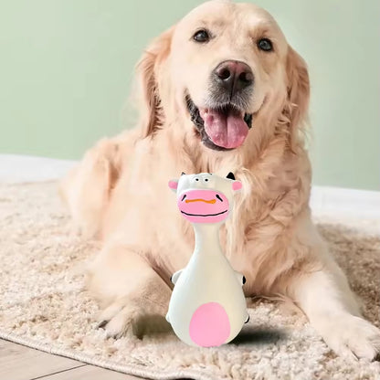 Dog resting with a white latex cow squeaky toy